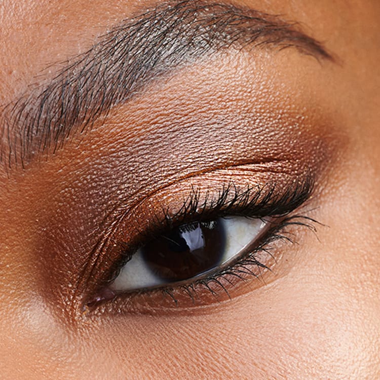 Close up of Vitamin Enriched Face Base with swatch behind over a pale blue background
